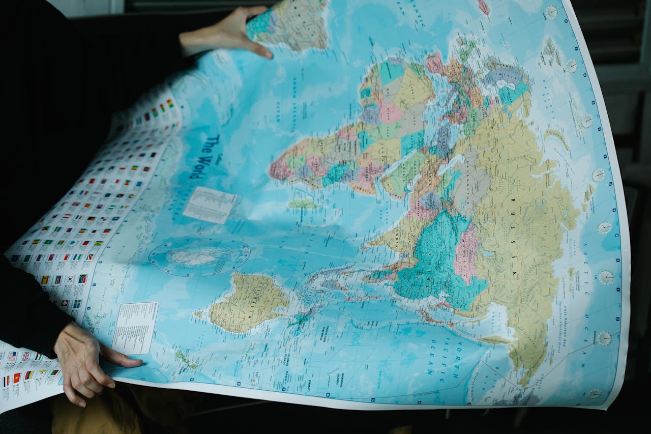about-bg A person is holding a detailed political world map with vibrant colors.